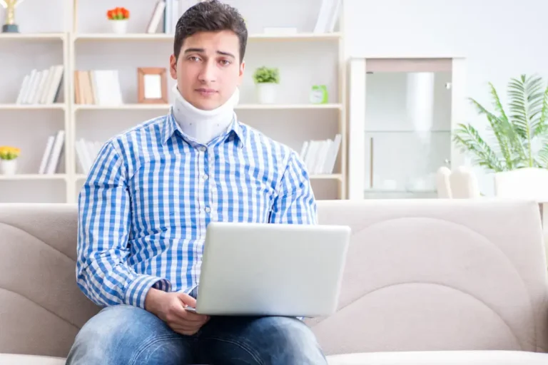 injured man on couch with computer