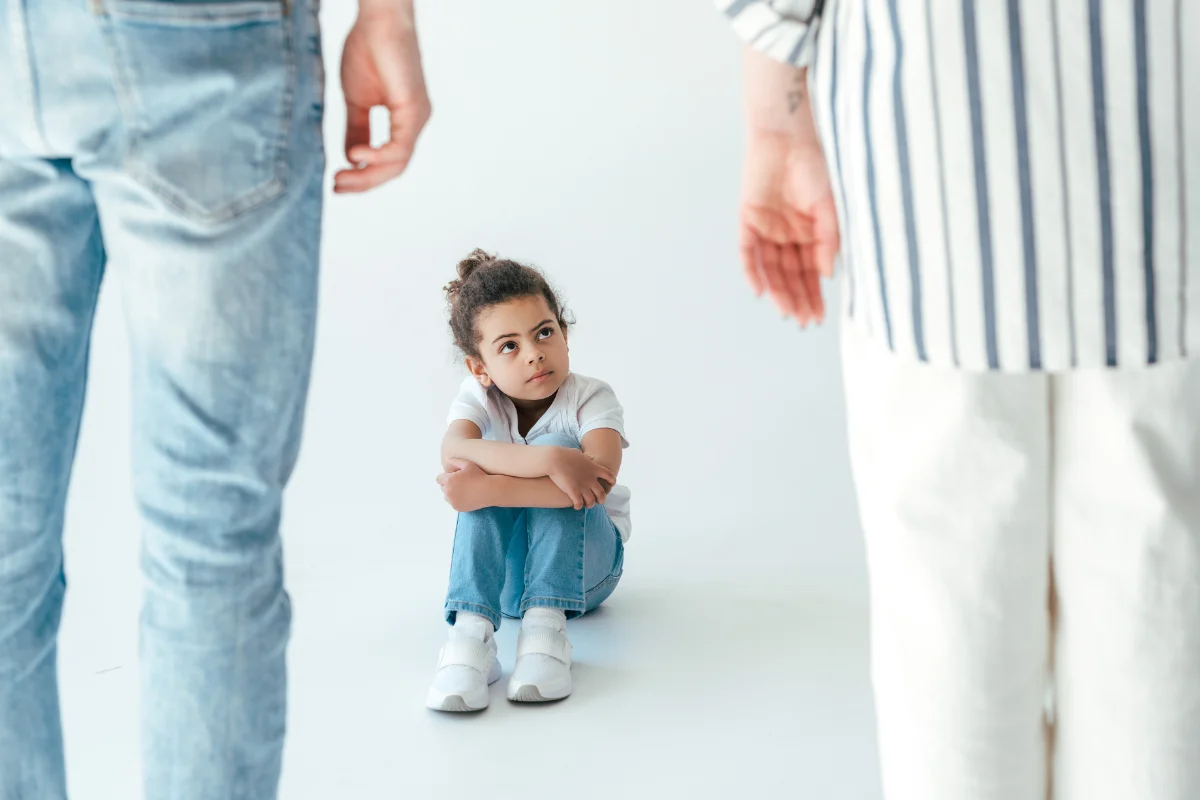 child stearnly facing parents